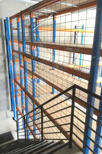 New rack shelving with mesh safety next to staircase